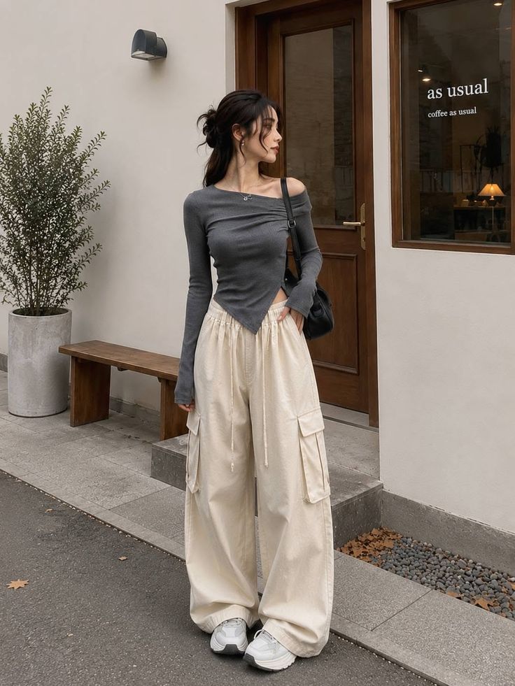 Woman in an off-shoulder top and cargo pants standing outdoors