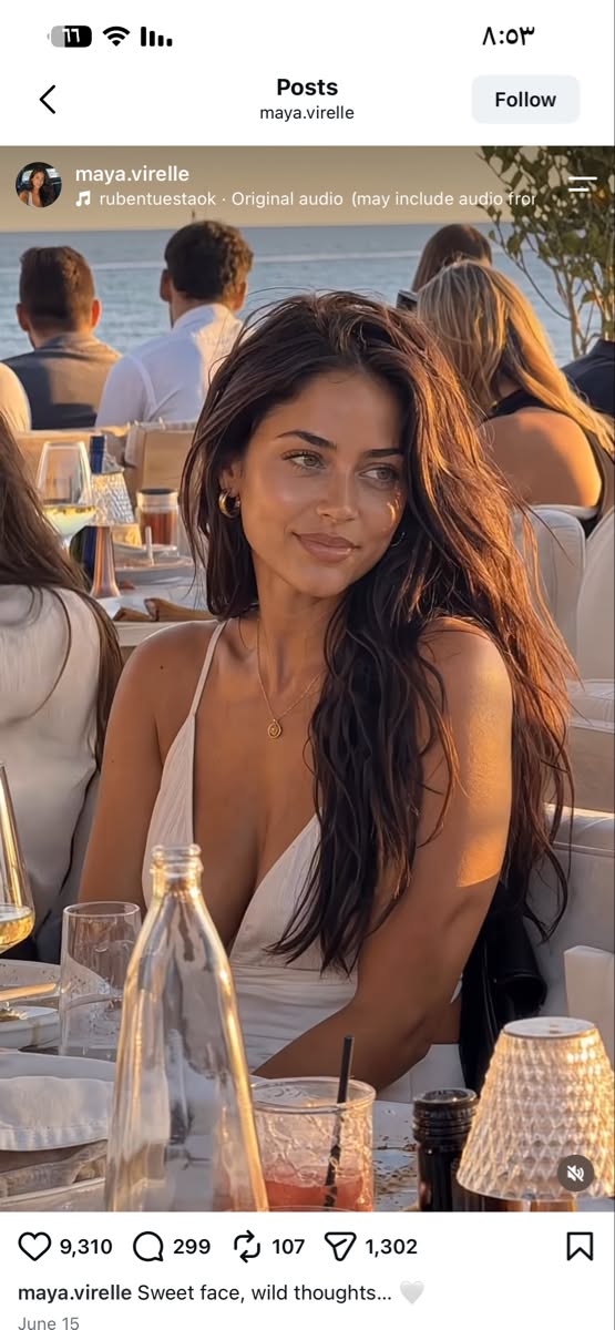 Woman with long hair in a white dress at an outdoor restaurant during golden hour