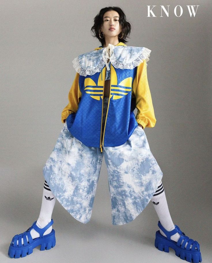 Woman with short hair in a blue and yellow jacket and tie-dye pants
