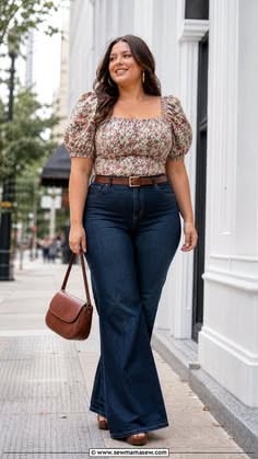 Woman in a floral top and flared jeans walking on a city street