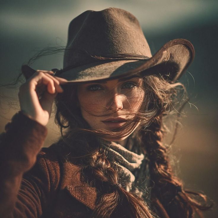 Woman in a cowboy hat with a long braid and windblown hair