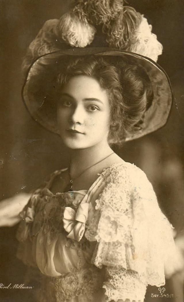 Vintage portrait of a woman in a large feathered hat and lace dress