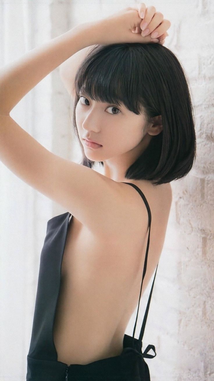 Woman with short black hair in a black dress with an exposed back