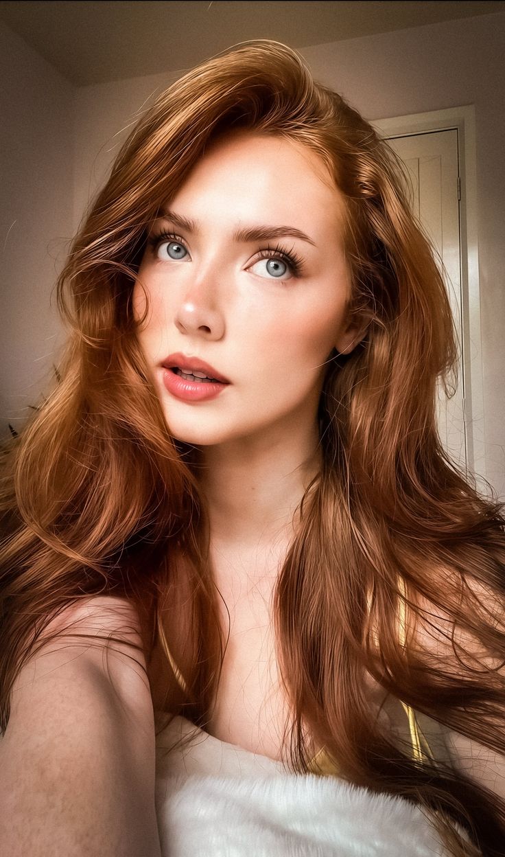 Woman with long red hair and blue eyes looking up