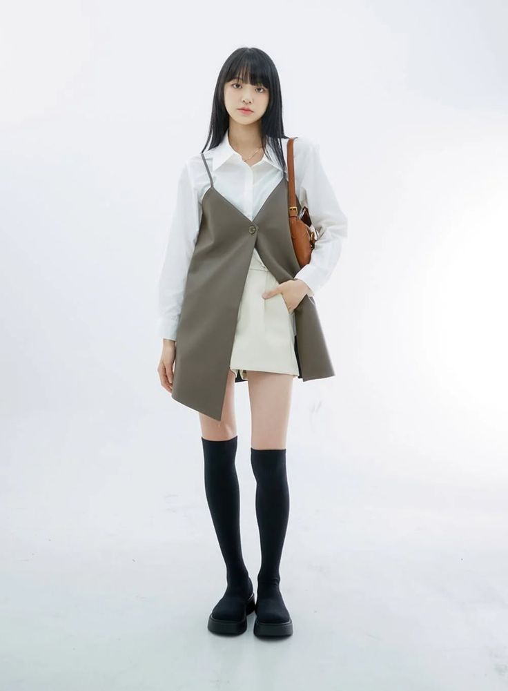 Woman with long black hair wearing a white shirt and sleeveless top with a mini skirt