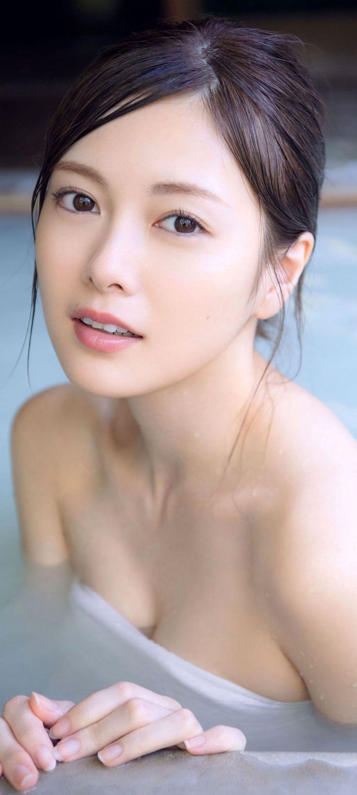 Woman with wet hair and exposed skin in a bath or hot spring