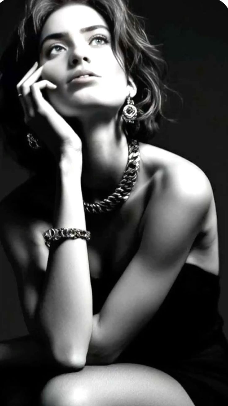 Woman with short hair and jewelry in a dramatic black and white portrait