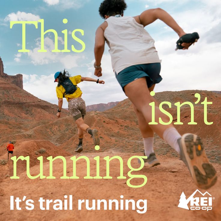 People trail running on a dirt path in a desert landscape