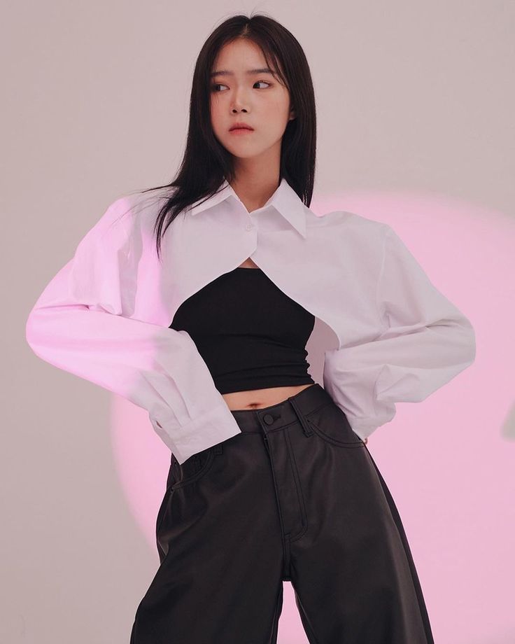 Woman in a white cropped shirt and black crop top with exposed midriff