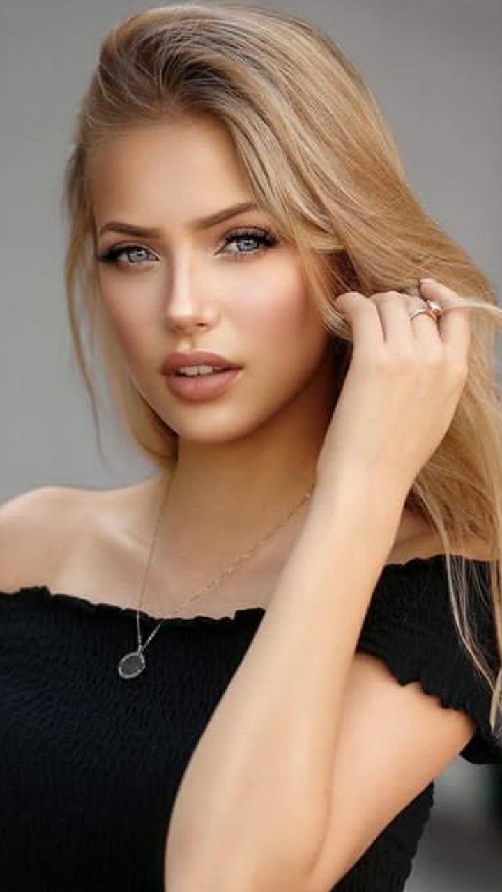 Woman with blonde hair wearing an off-shoulder top and necklace