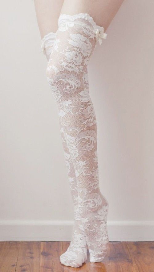 Legs wearing white lace thigh-high stockings with bows