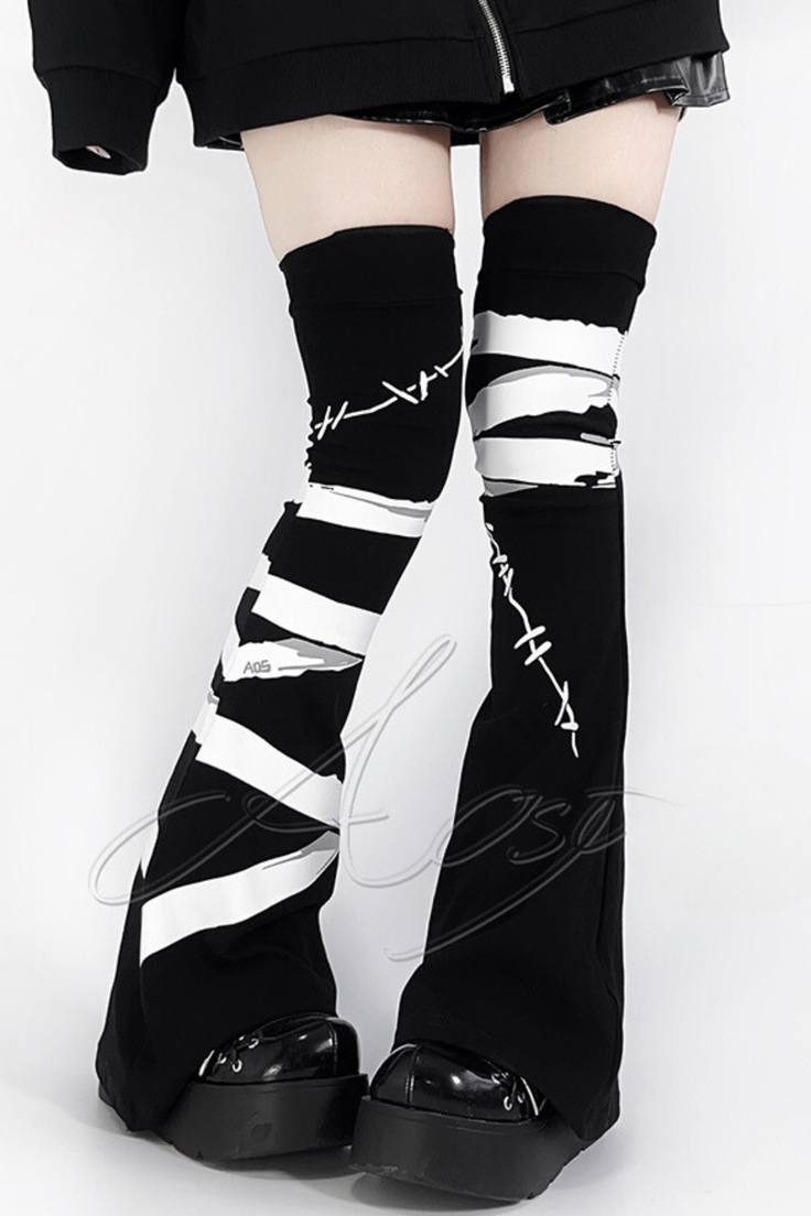 Person wearing black and white thigh-high socks and platform shoes
