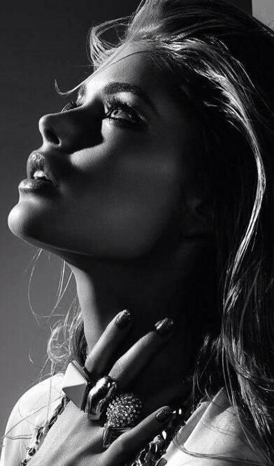 Black and white portrait of a woman with dramatic lighting and jewelry