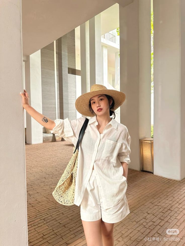 Woman in a straw hat and white outfit posing outdoors