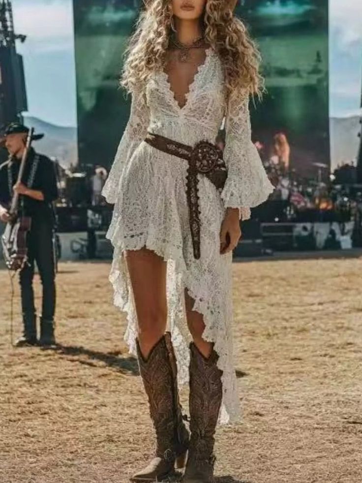 Woman in a white lace dress and cowboy boots at an outdoor music festival