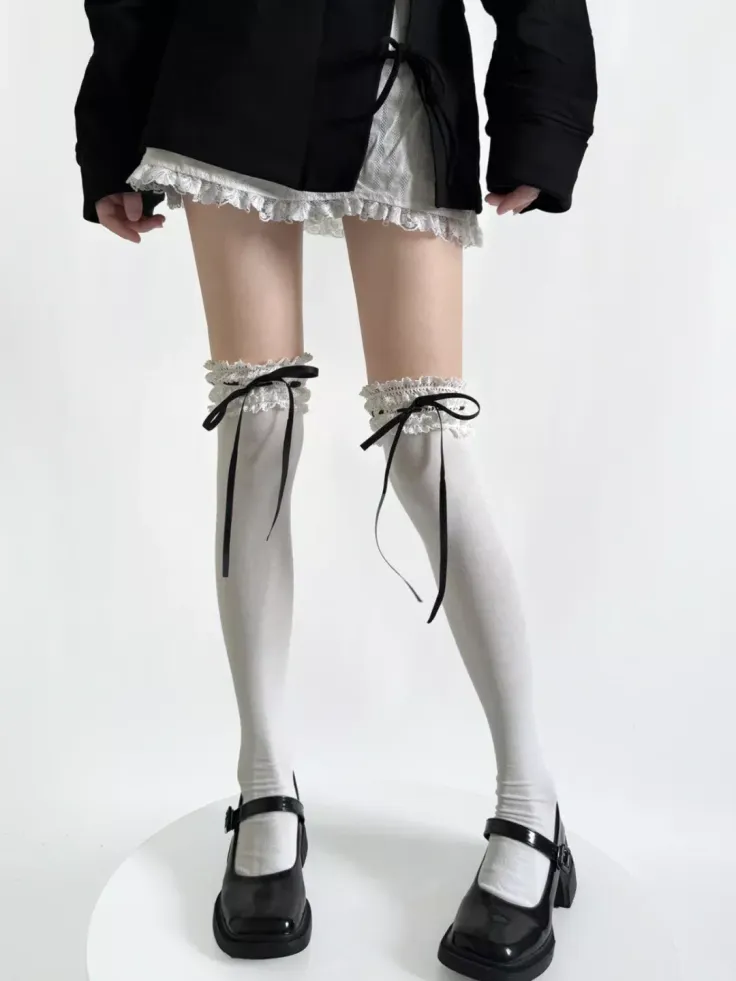 Person wearing thigh-high socks with black ribbons and Mary Jane shoes