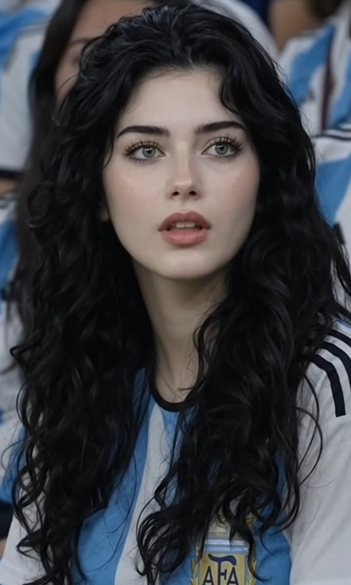 Woman with long black hair and green eyes wearing an Argentina jersey