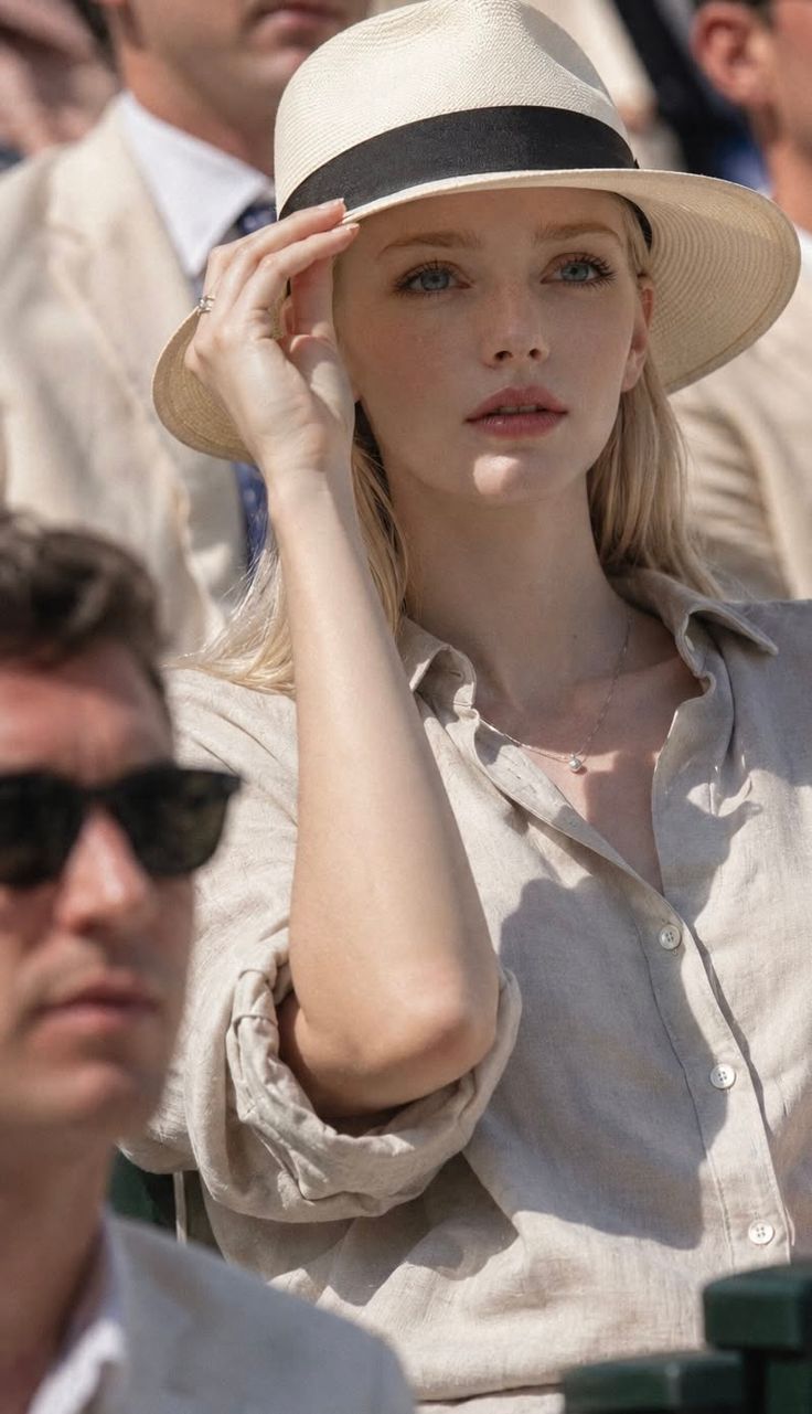 Blonde woman in a straw hat and linen shirt outdoors