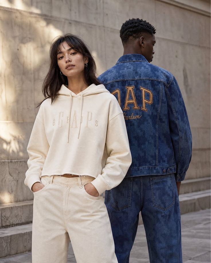 Two people in casual streetwear, a woman in a cream hoodie and a man in a denim jacket