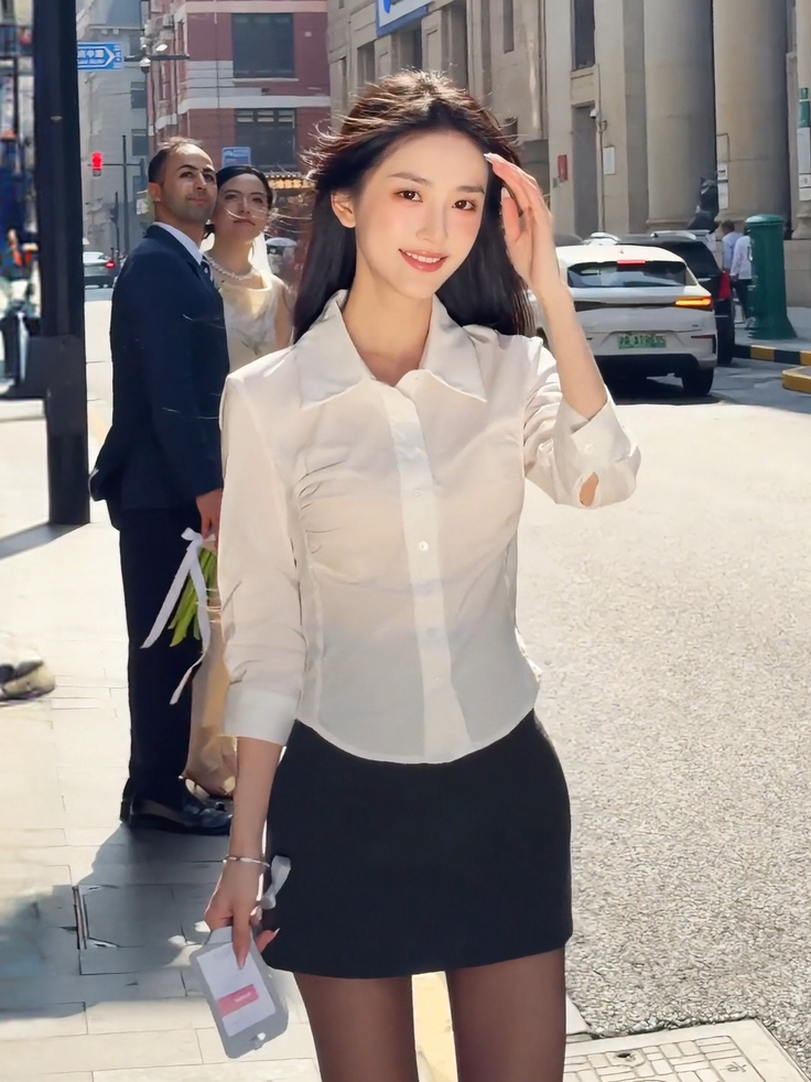Woman in a white shirt and black skirt smiling on a sunny street