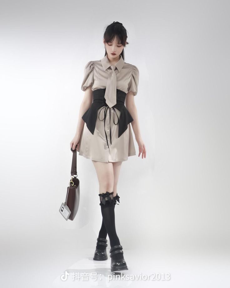 Woman in a short dress with a corset belt and knee-high socks in a studio