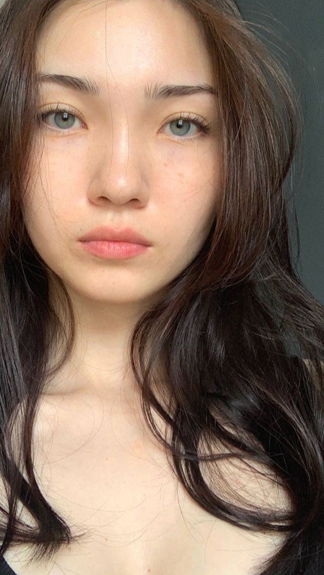 Close up portrait of a woman with long dark hair and green eyes