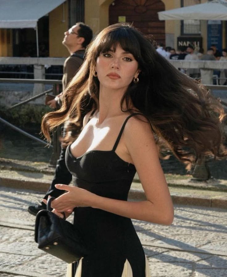 Woman with long hair and a black dress on a street