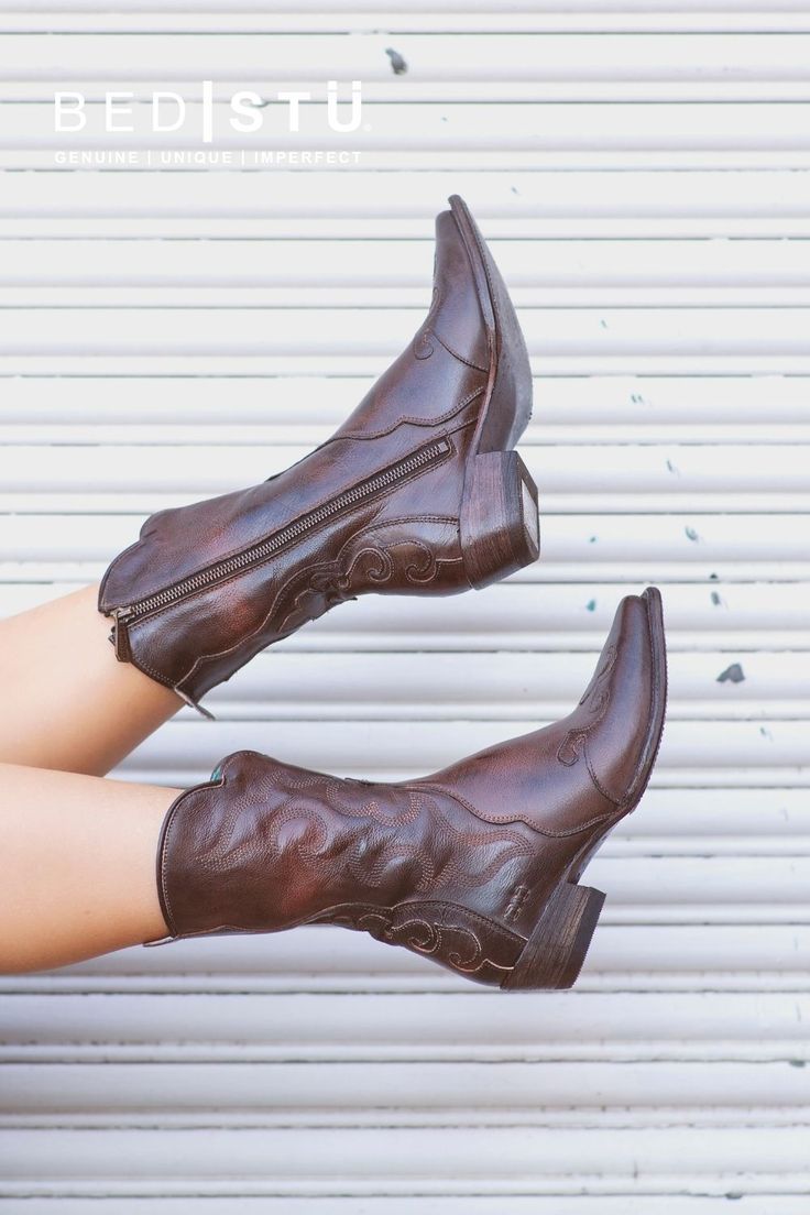 Pair of brown leather cowboy boots with embroidered design and zippers