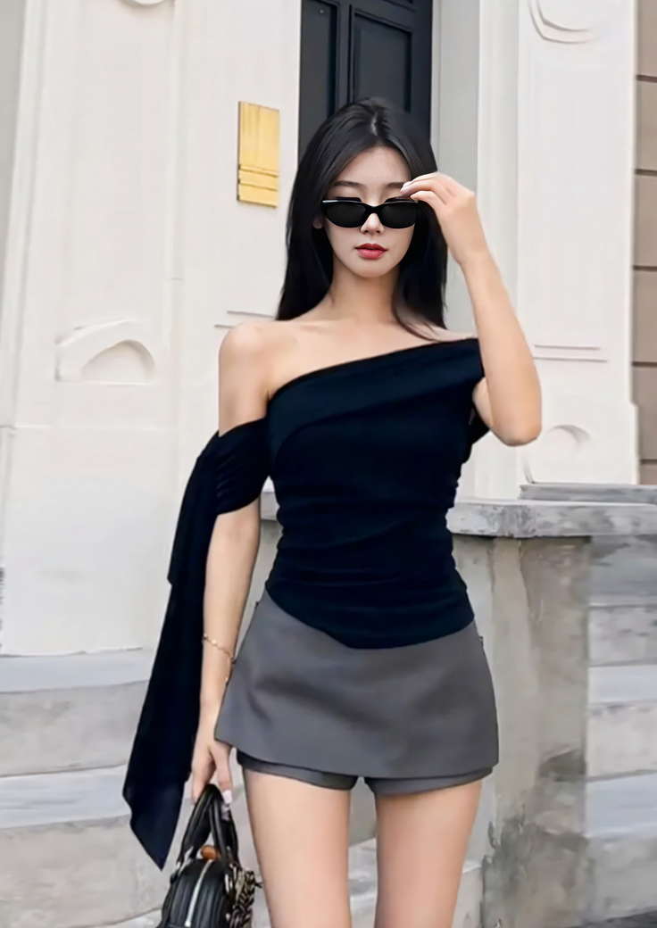 Woman with long black hair and sunglasses wearing an off-shoulder top and mini skirt