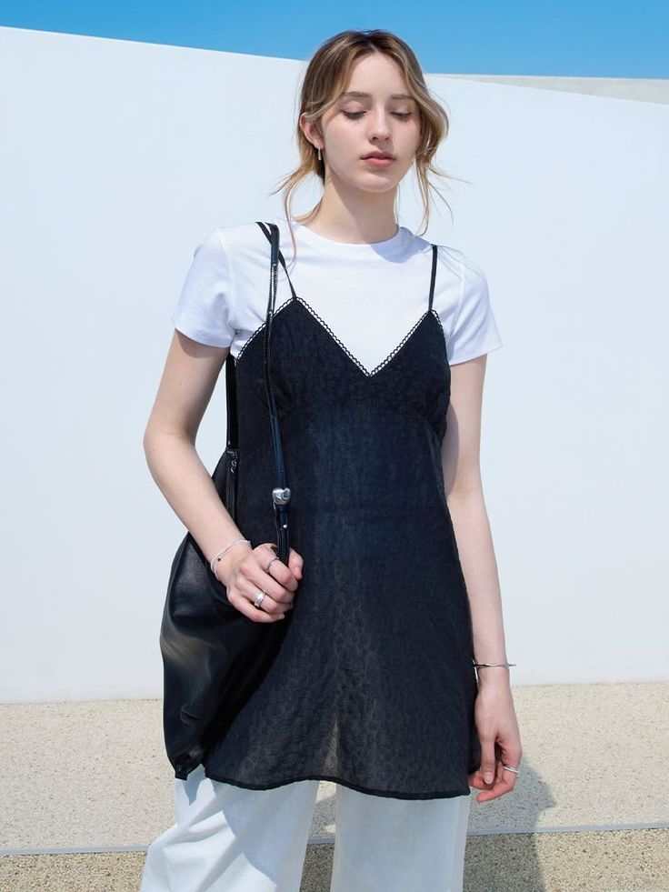Woman in a black slip dress over a white t-shirt outdoors