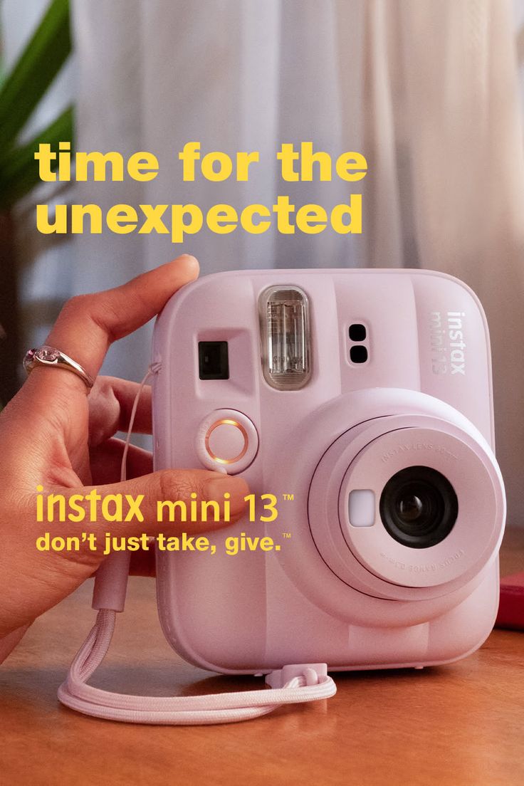 Hand holding a pink instant camera with text overlay
