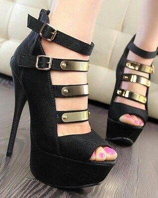Pair of black high heels with gold accents and pink nail polish