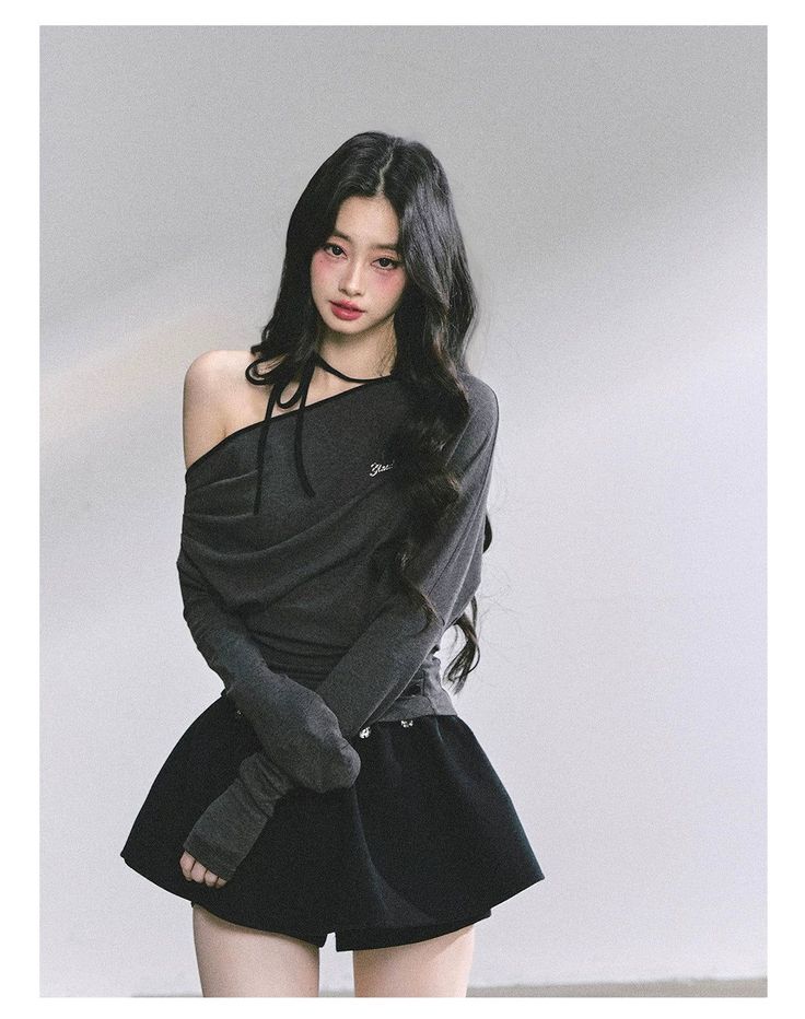 Woman with long black hair wearing an off-shoulder top and black skirt