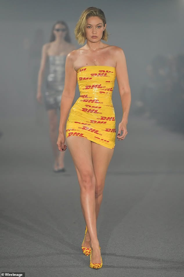 Woman in a yellow strapless dress walking on a runway
