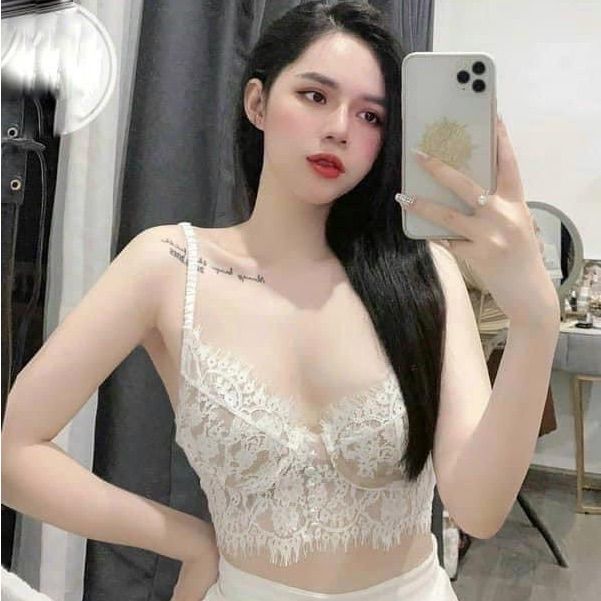 Woman in a white lace top taking a selfie indoors