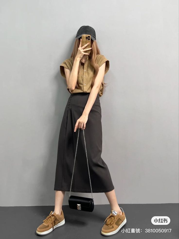 Person in a baseball cap and midi skirt taking a mirror selfie indoors