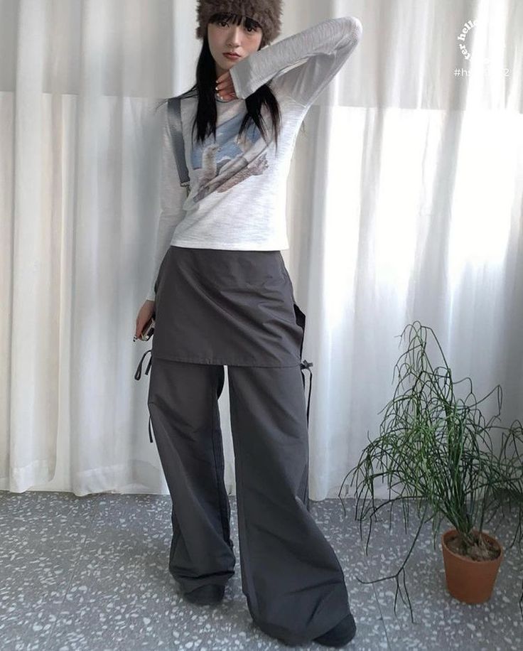 Woman in a fur hat and wide leg pants posing indoors