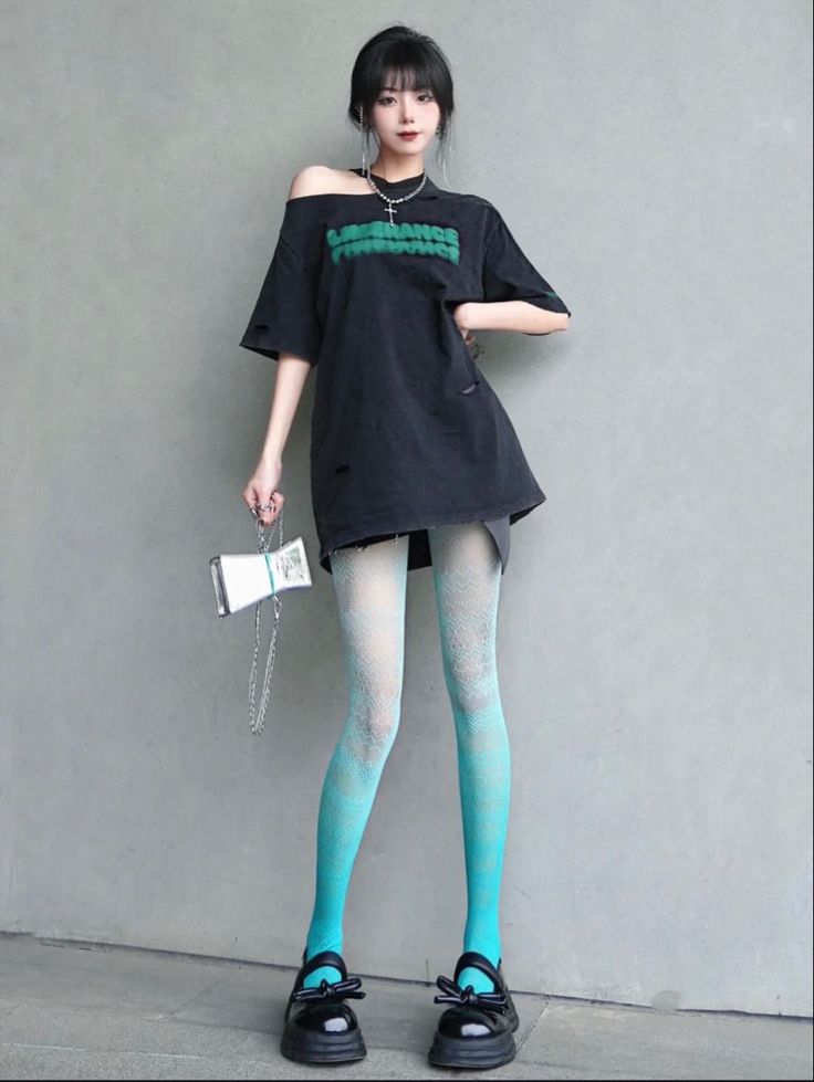 Woman in an off-shoulder top and ombre tights against a gray background