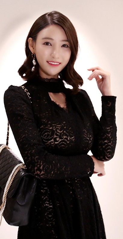 Woman in a black lace dress with a choker and quilted bag