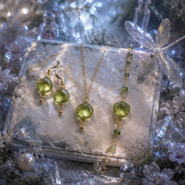 Jewelry set with green gemstones and gold chains on a decorative background