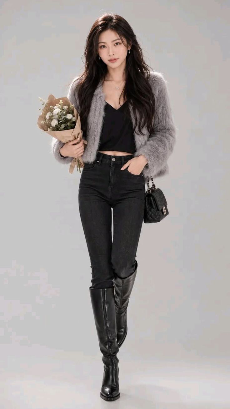 Woman in a gray fur jacket, black top, and jeans holding a bouquet