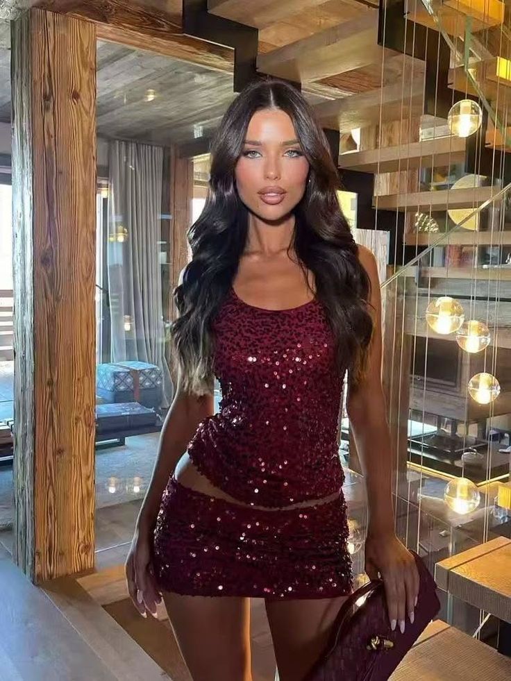 Woman in a sequin top and mini skirt posing indoors