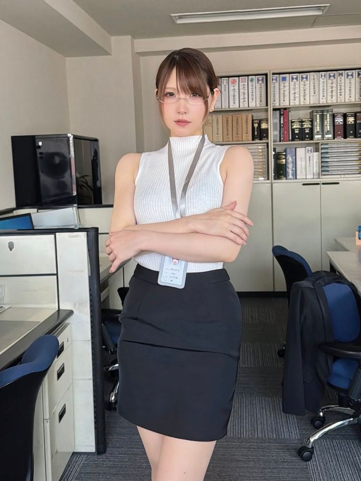 Woman in a white top and black skirt standing in an office