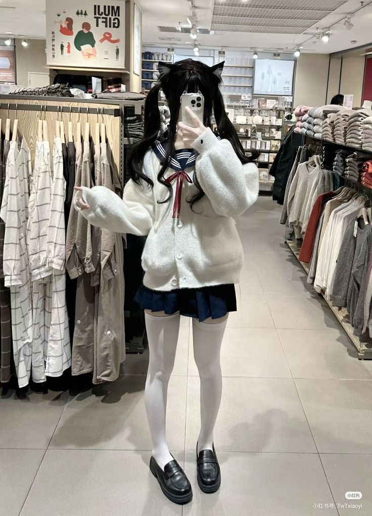 Person in a school uniform with cat ears and twin tails taking a mirror selfie