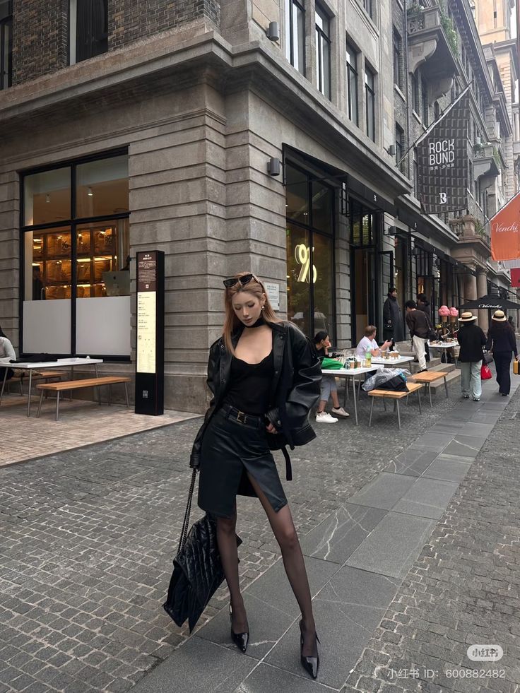 Woman in a black leather jacket and mini skirt on a city street