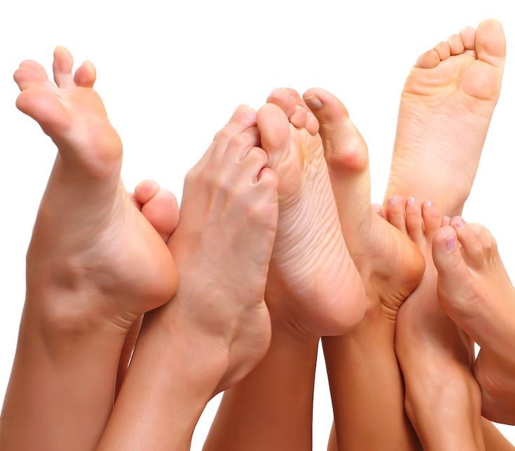 Multiple bare feet with soles and toes visible against a white background