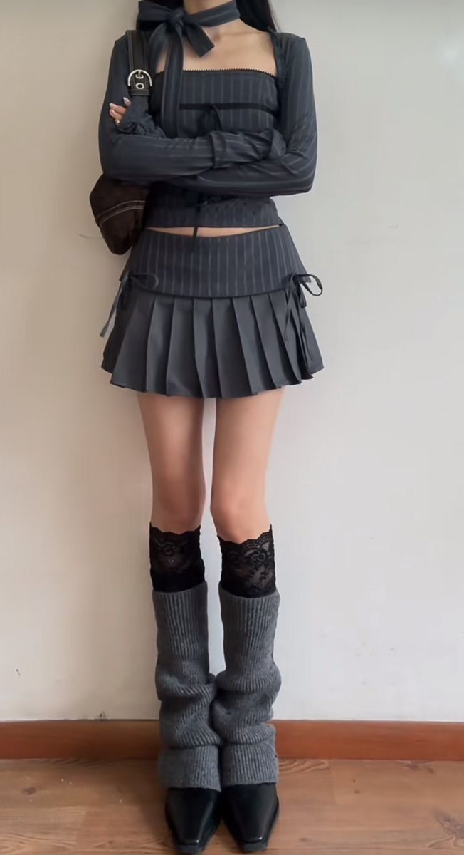 Person in a pinstripe top and mini skirt with leg warmers and lace socks