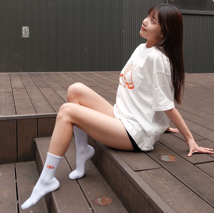 Woman with long dark hair sitting on wooden steps outdoors