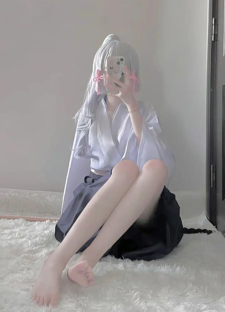 Person with white hair and pink ribbons wearing a kimono, sitting on a white rug