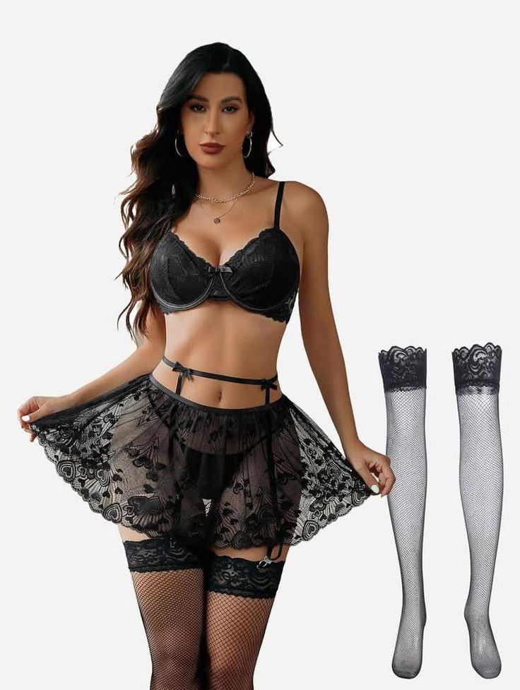 Woman in black lace lingerie and fishnet stockings posing in a studio